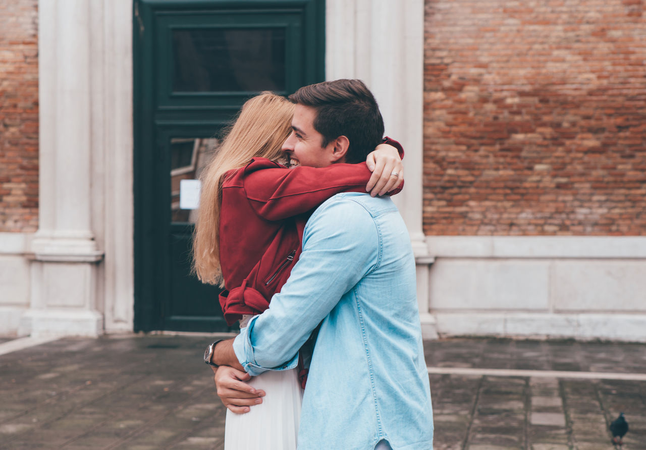 SIDE VIEW OF COUPLE KISSING