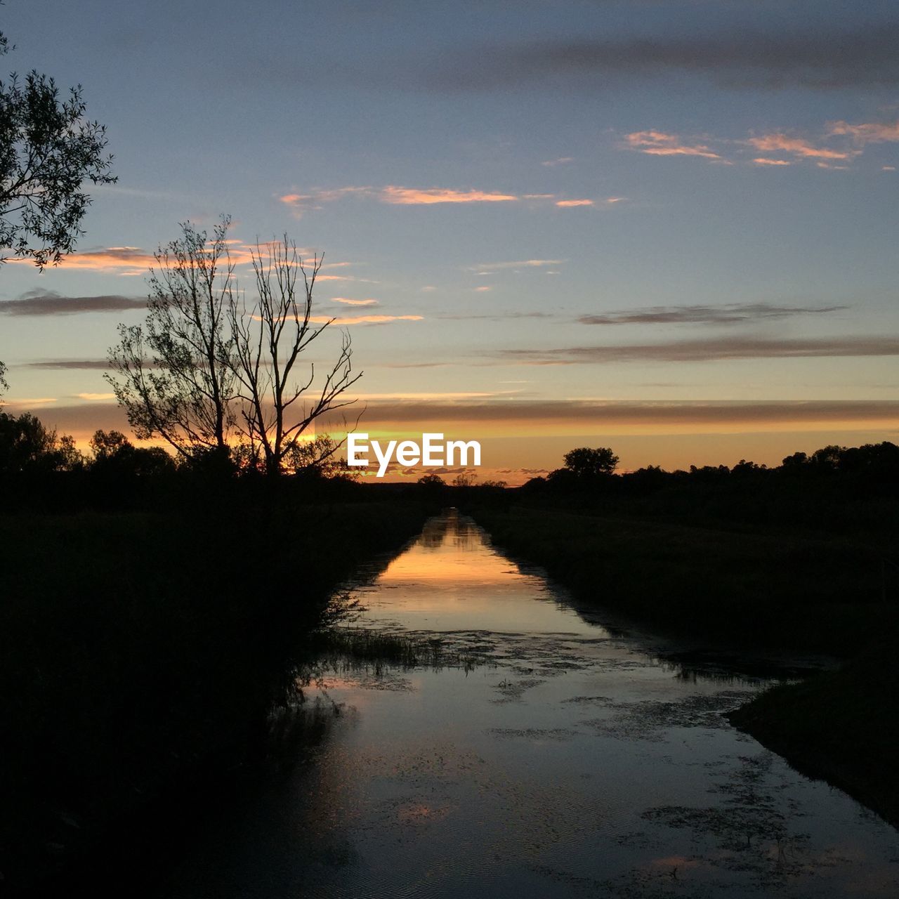 SCENIC VIEW OF LAKE AT SUNSET