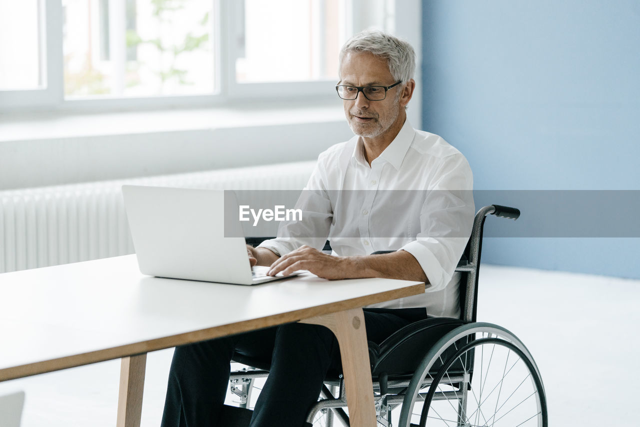 Handicapped manager in a wheelchair, working in office