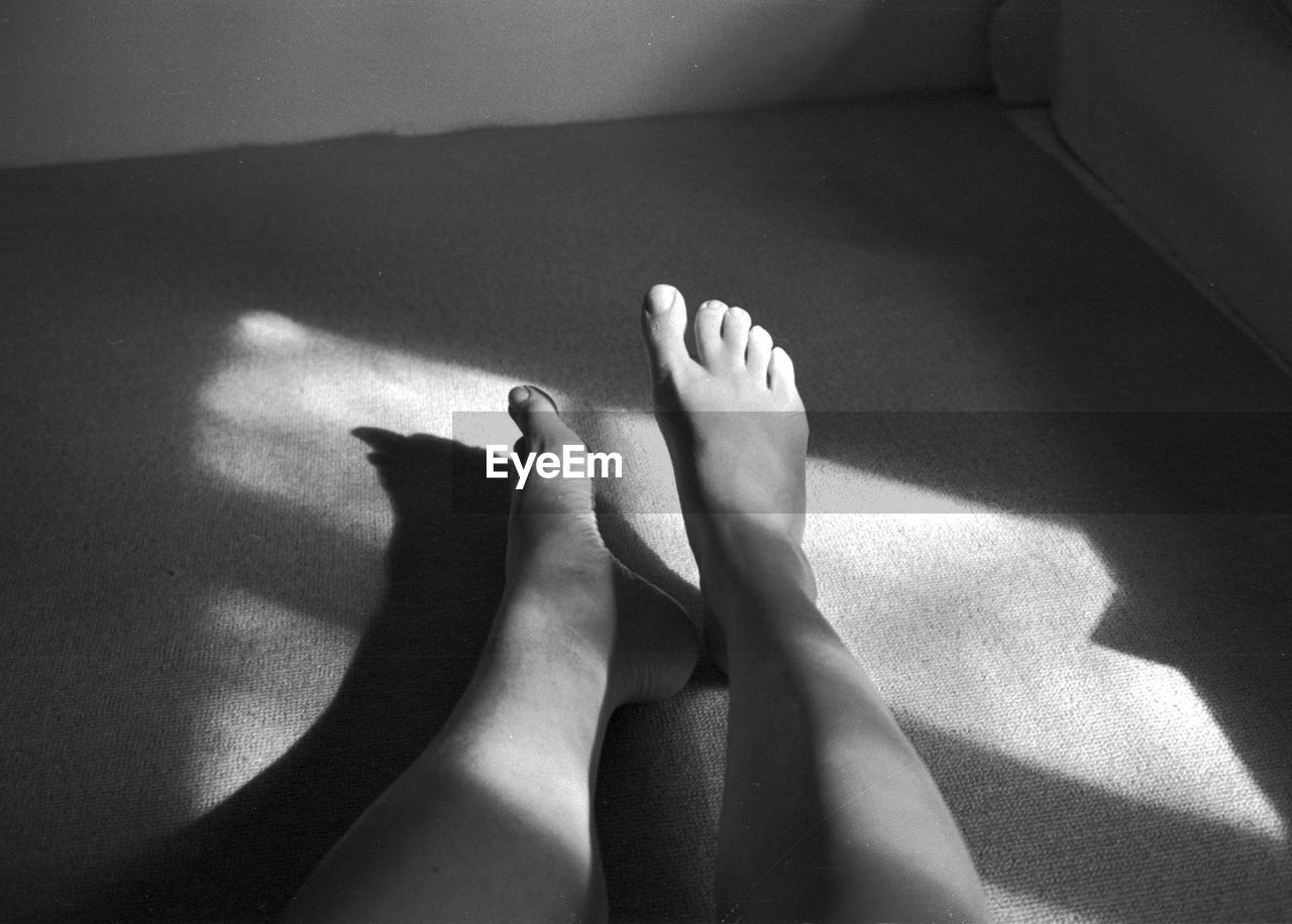 black, white, black and white, shadow, low section, human leg, barefoot, monochrome photography, one person, indoors, monochrome, human foot, close-up, adult, limb, women, hand, human limb, sunlight, lifestyles, personal perspective, finger, darkness, high angle view, relaxation, home interior, toe, domestic room, leisure activity