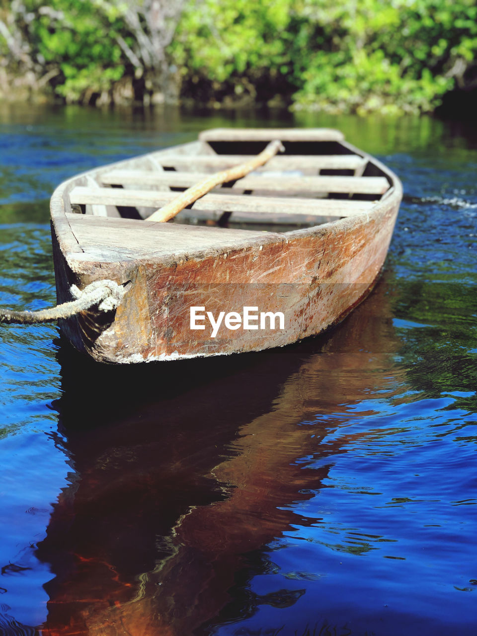 CLOSE-UP OF RUSTY BOAT MOORED IN LAKE