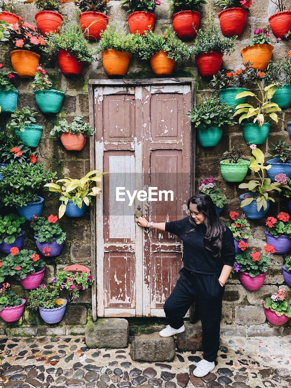 Woman standing by potted plants