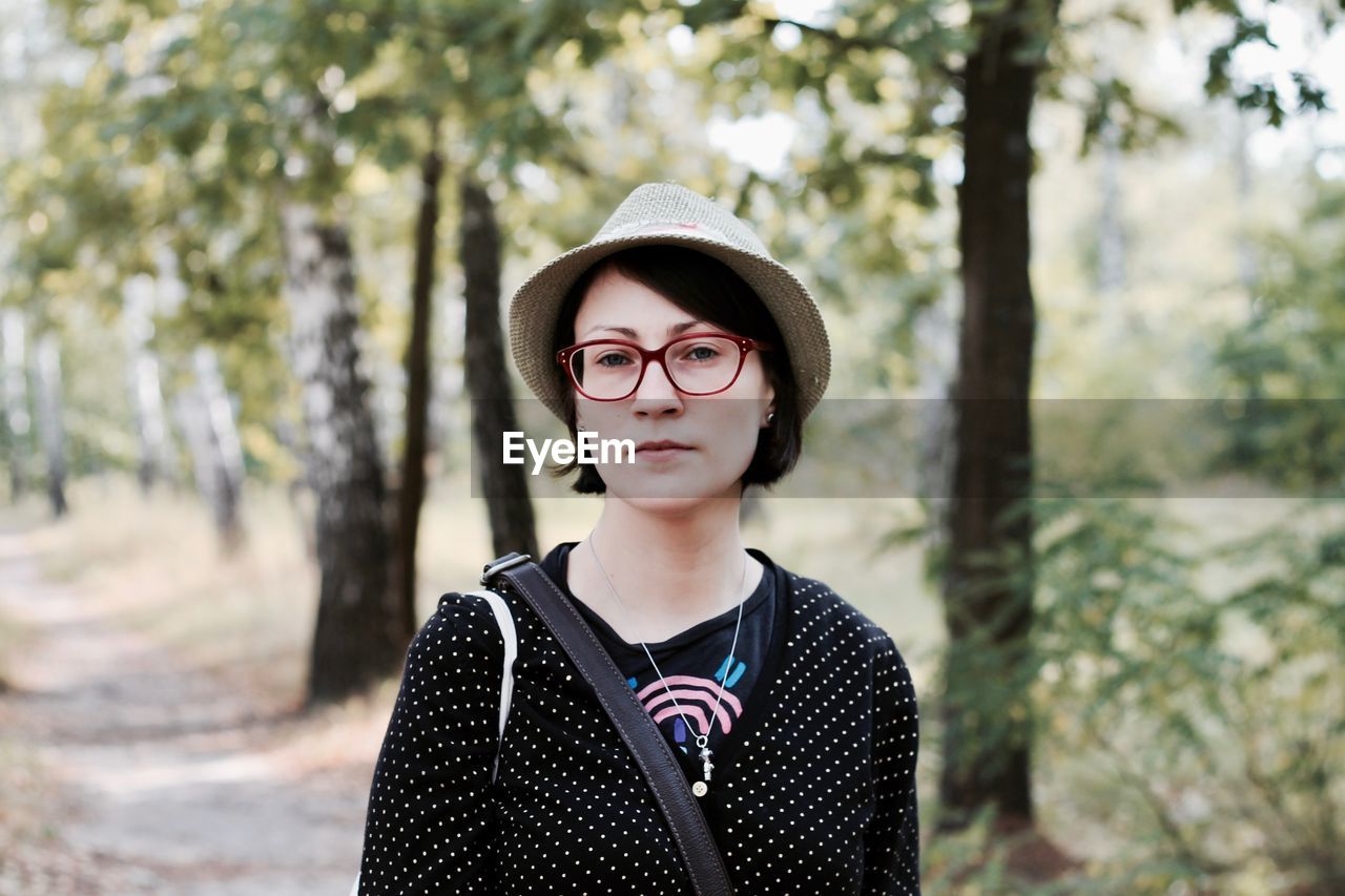 Portrait of smiling woman standing in forest