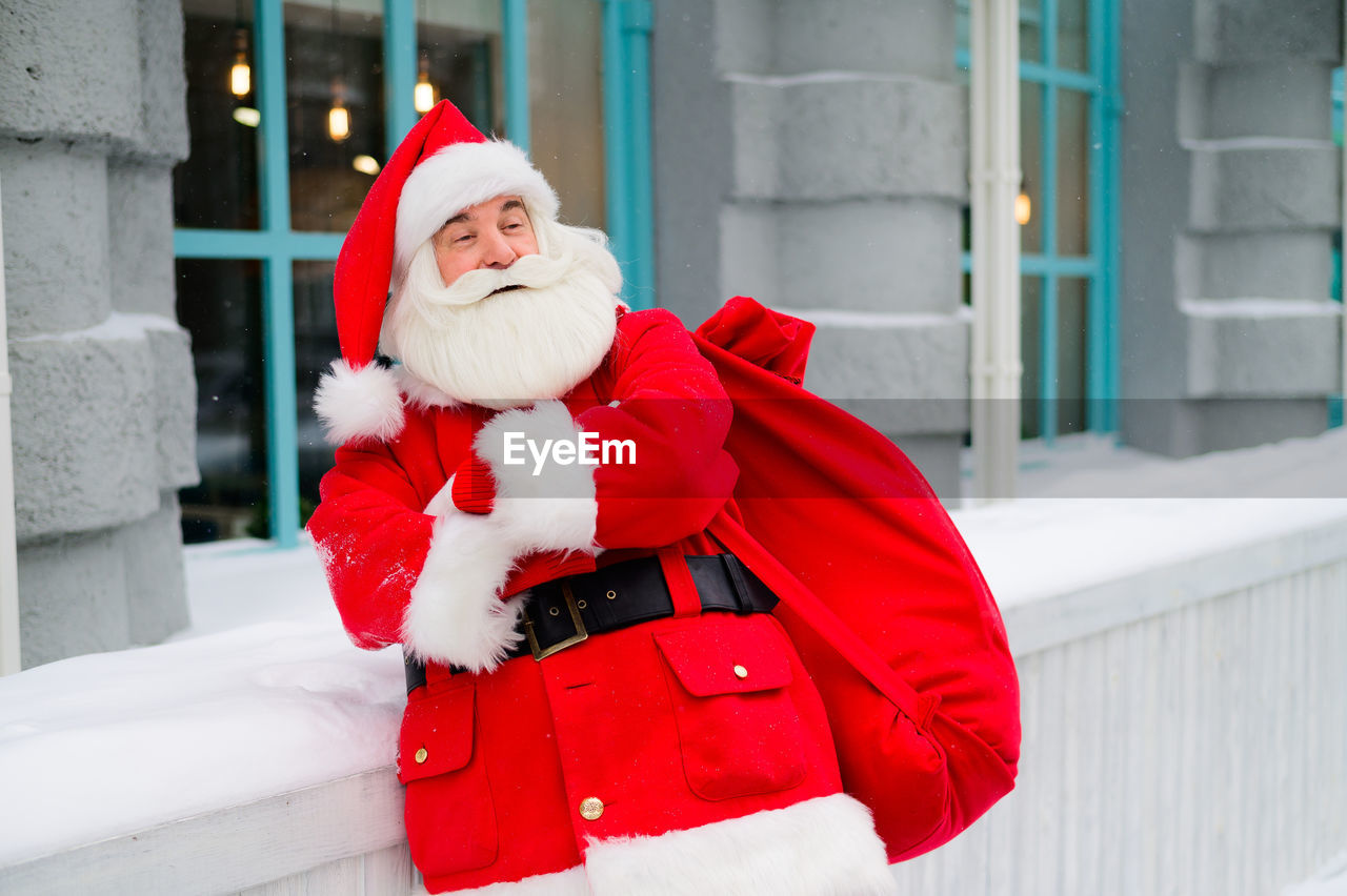 Portrait of smiling young woman wearing santa claus costume