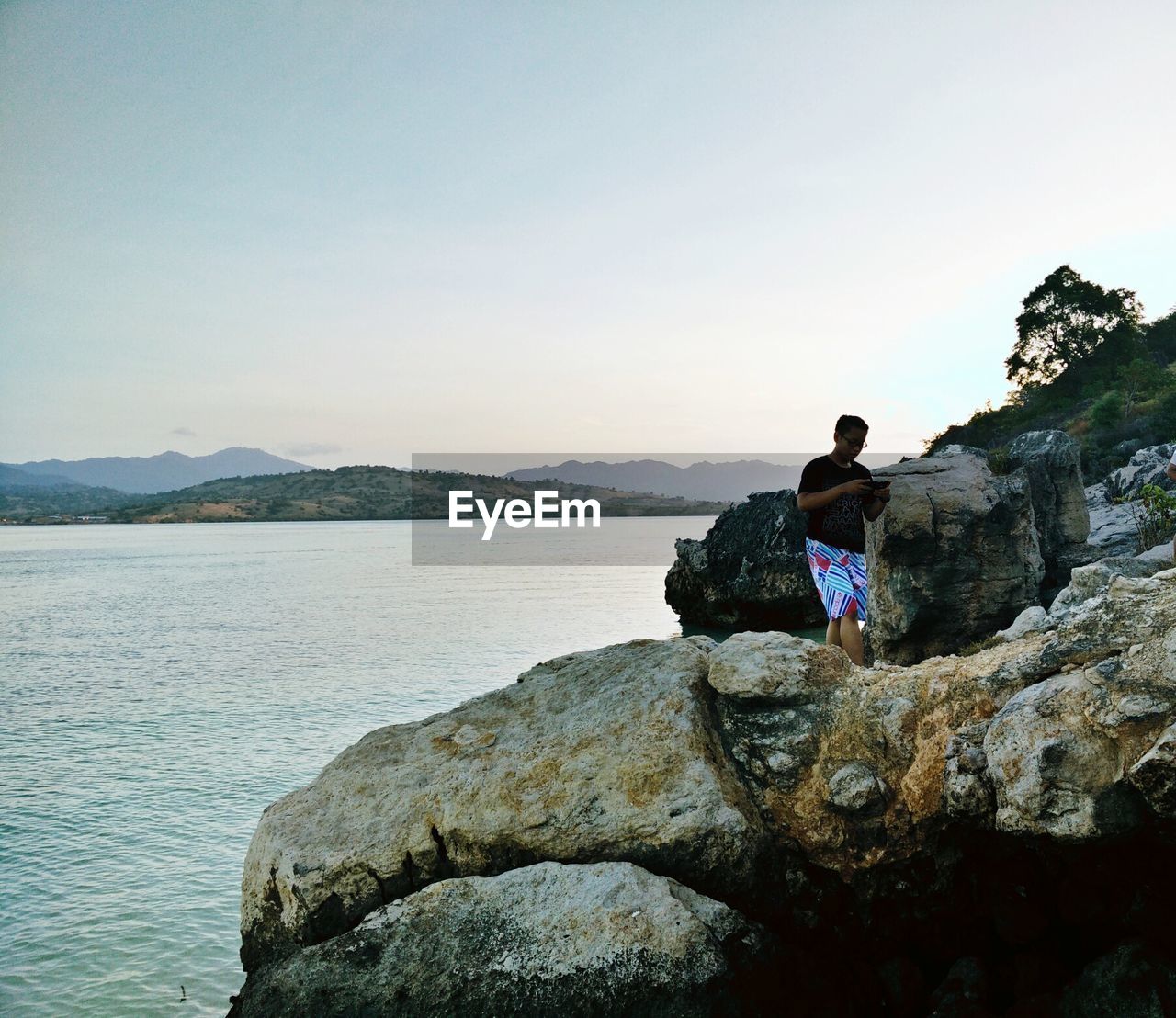 WOMAN STANDING ON ROCKS