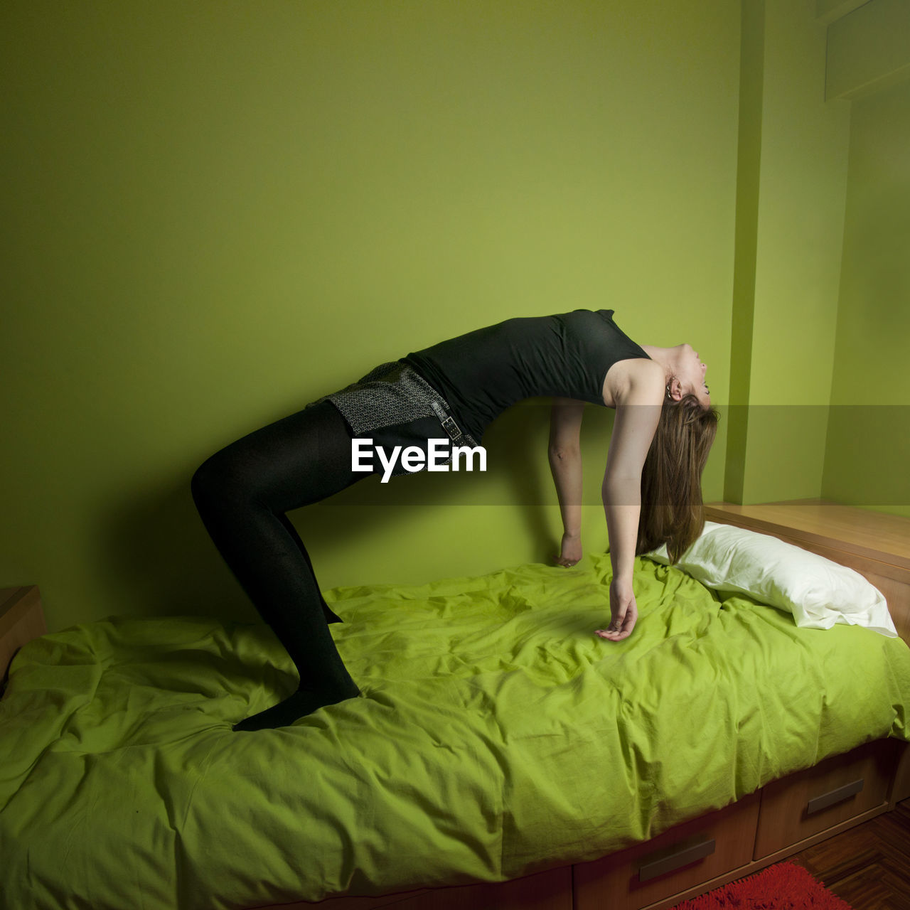 Full length of woman levitation over bed at home