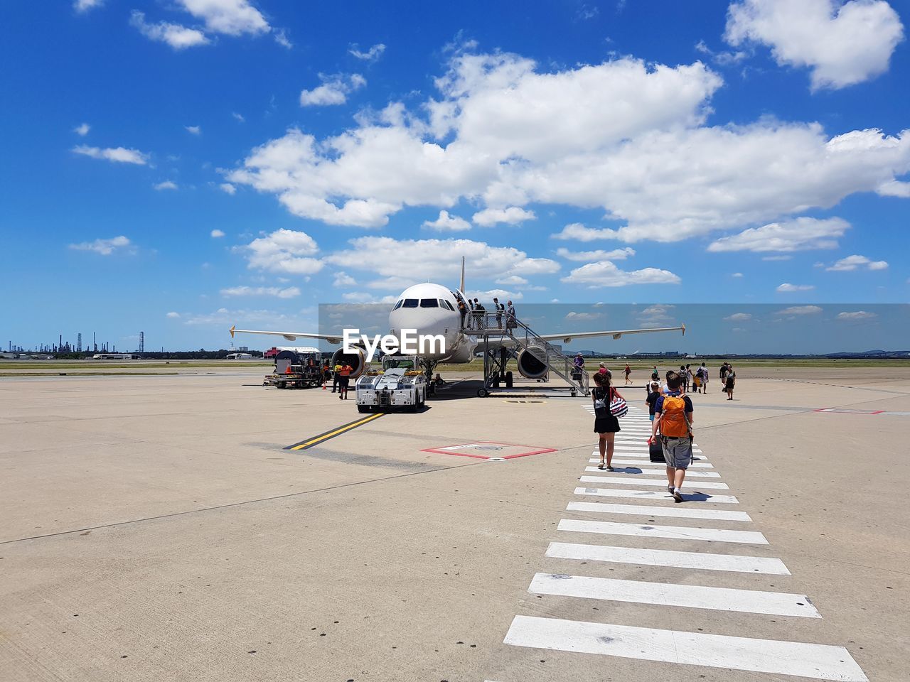 PEOPLE AT AIRPORT RUNWAY AGAINST AIRPLANE