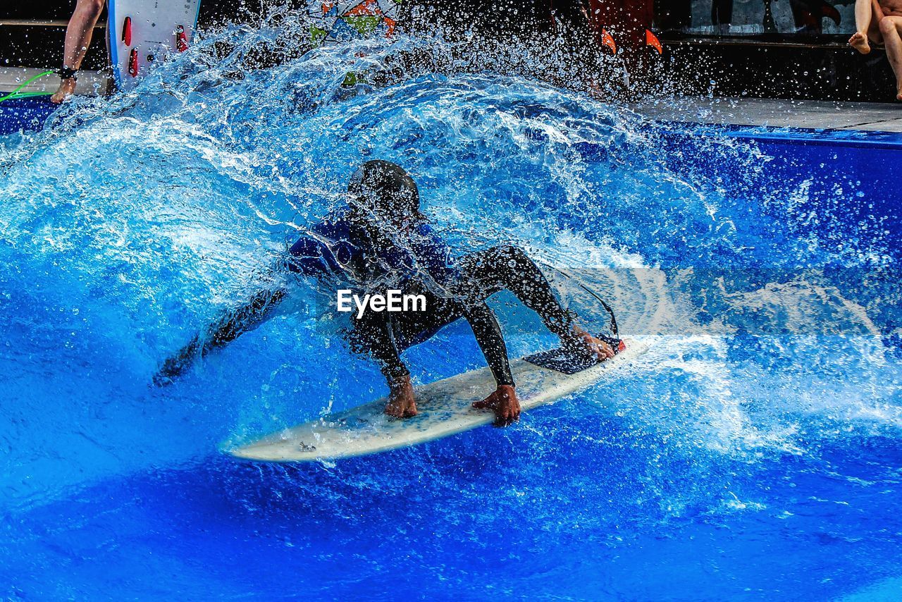 Surfer surfing in swimming pool at water park