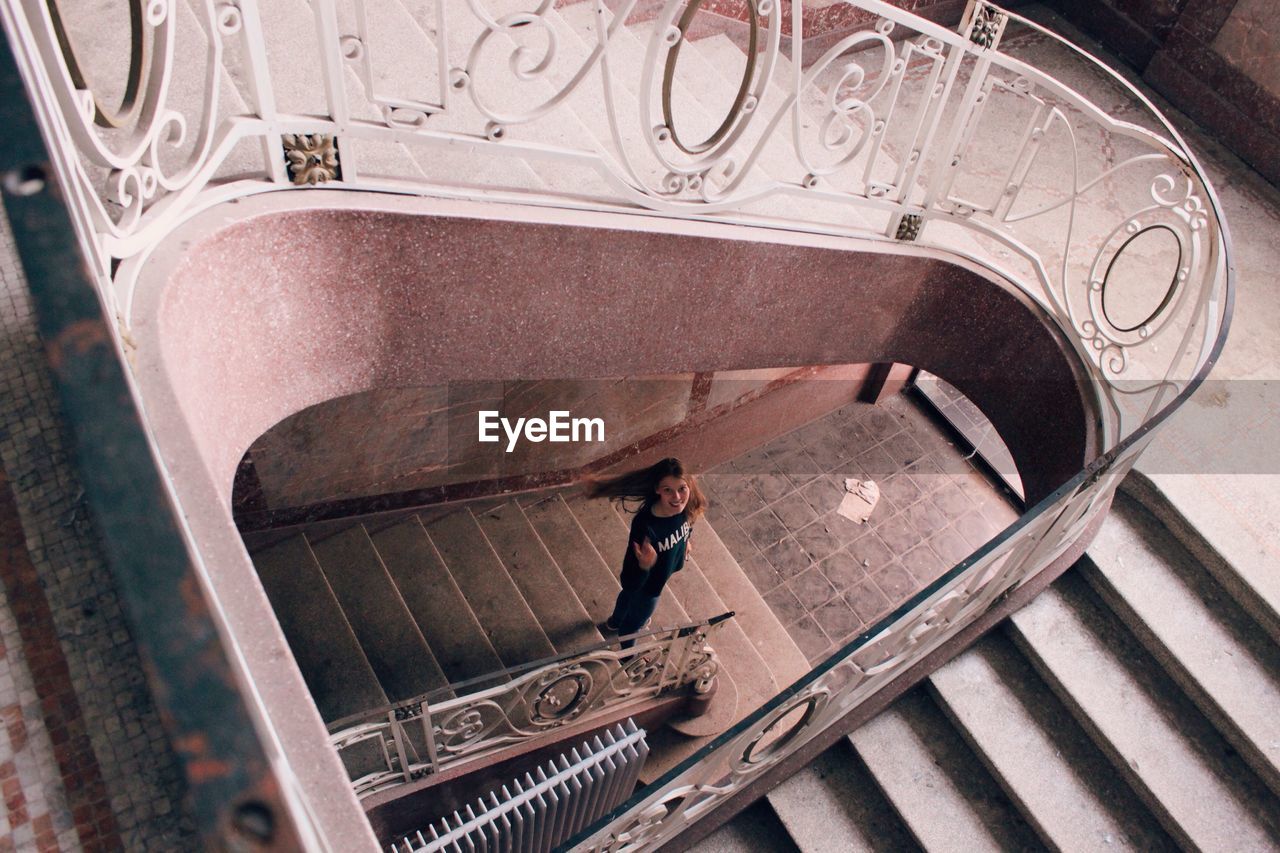 High angle portrait of woman standing on steps