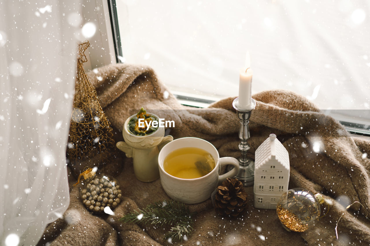 Hot tea, candles, christmas golden balls and decorations. christmas holiday mood