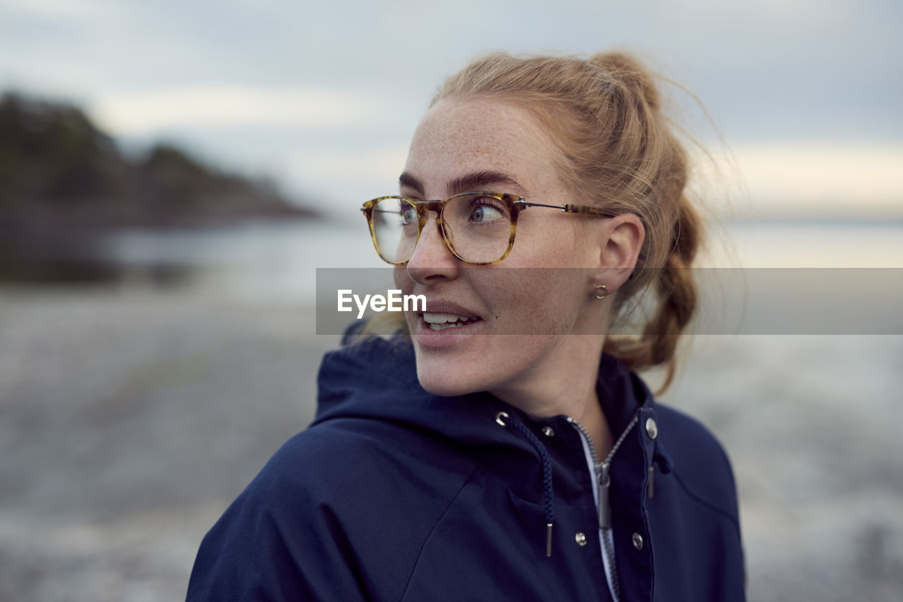 Young woman looking away at beach during sunset