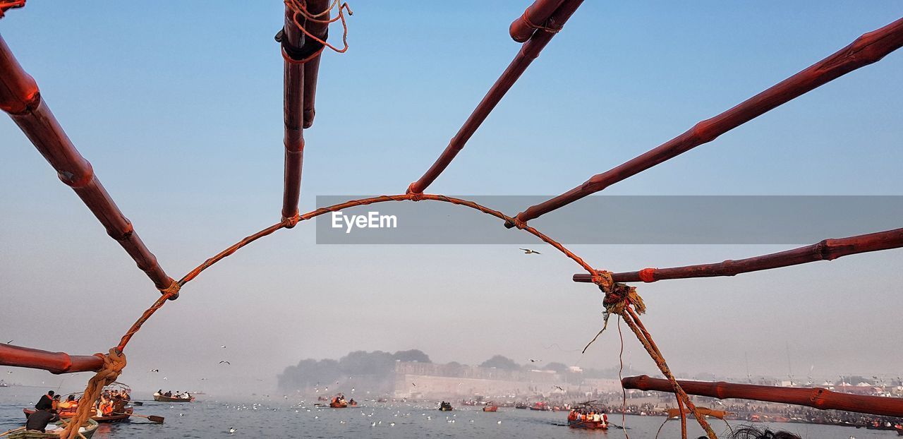 CRANES AGAINST SKY IN SEA