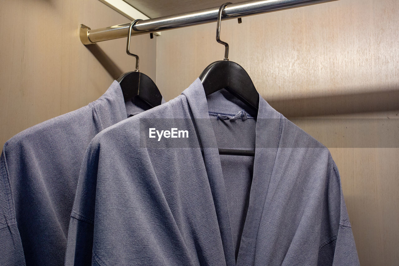 Close-up of clothes hanging on rack in shelf