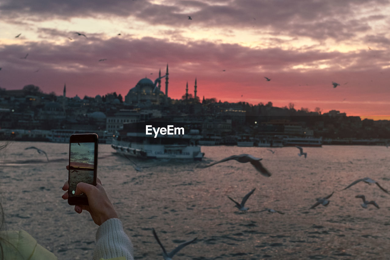 MAN PHOTOGRAPHING AT SUNSET