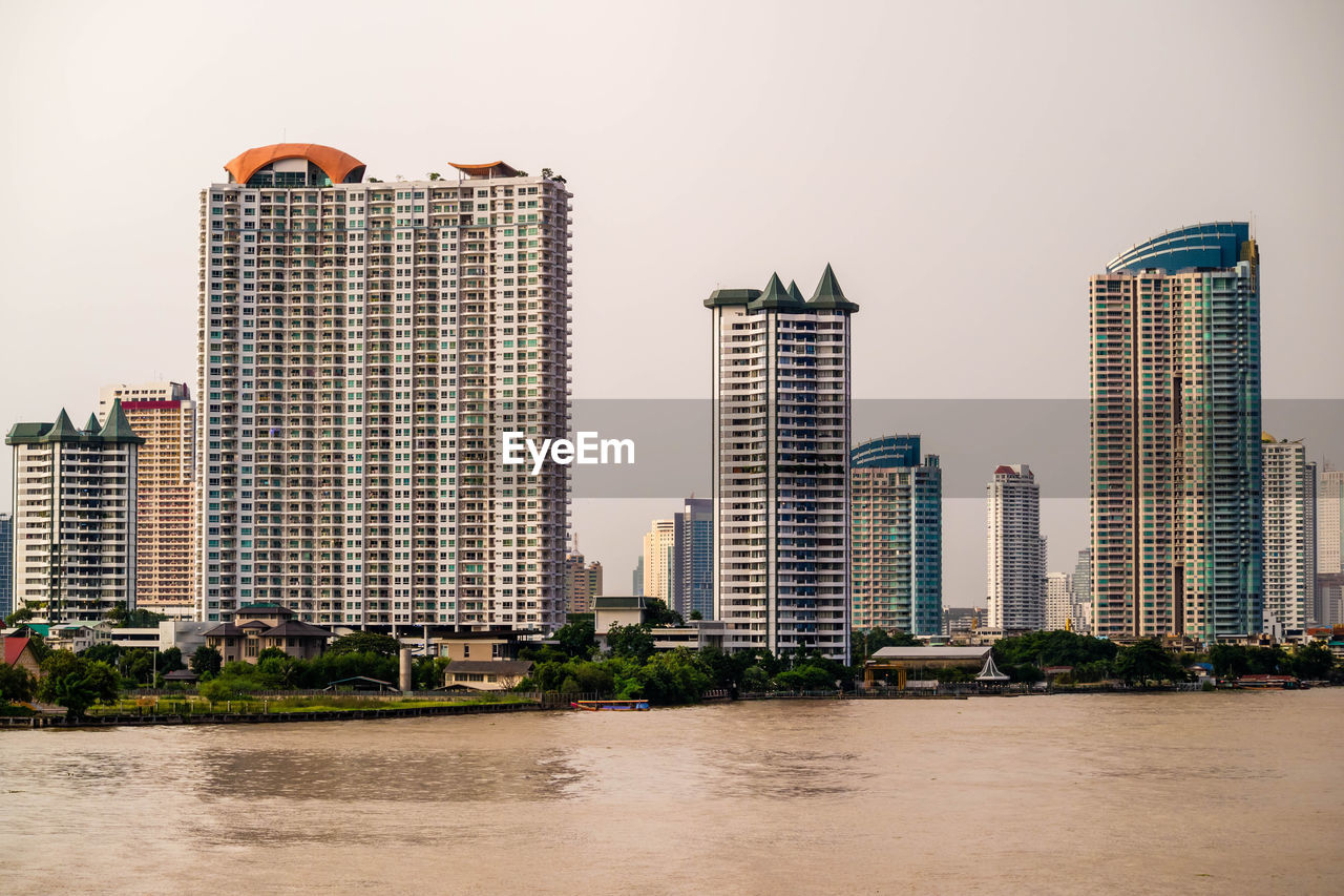 VIEW OF CITYSCAPE BY SEA AGAINST SKY