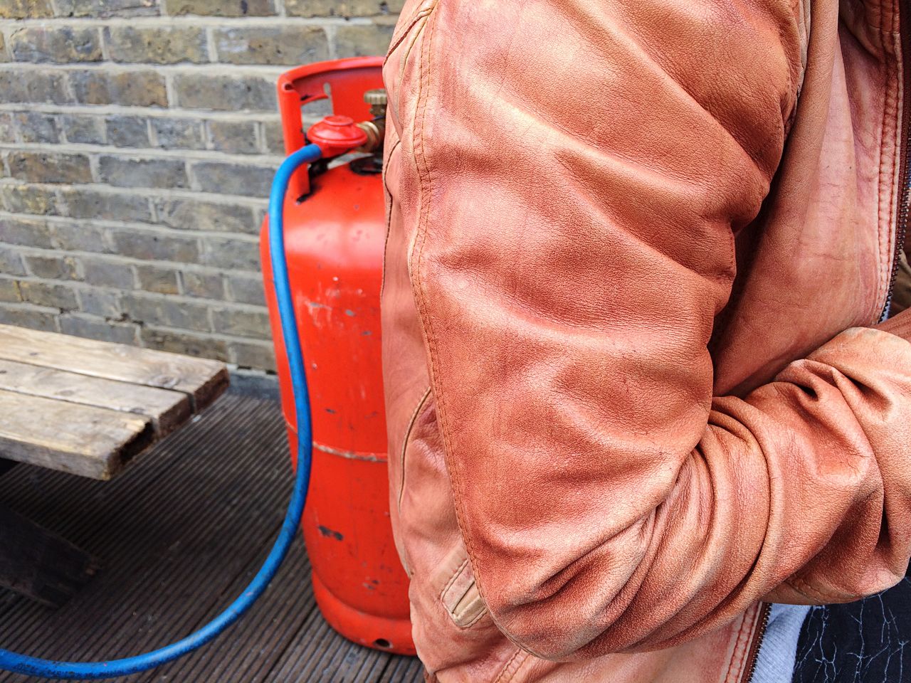 Midsection of person standing against red cylinder