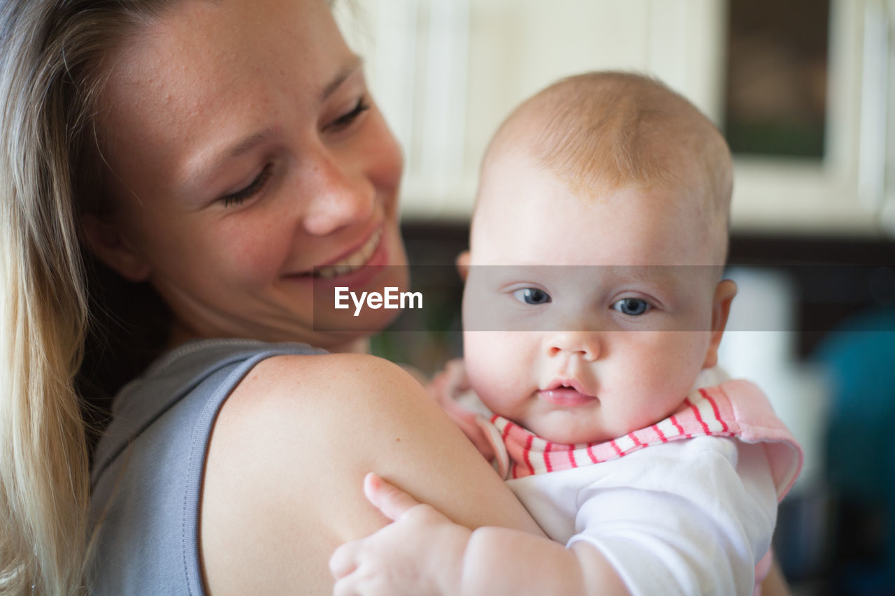 Portrait of baby with mother at home