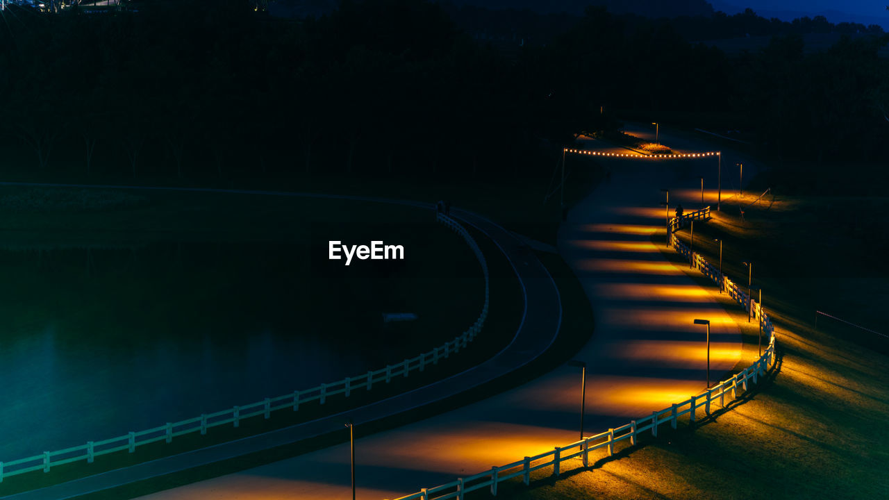 High angle view of illuminated road by lake