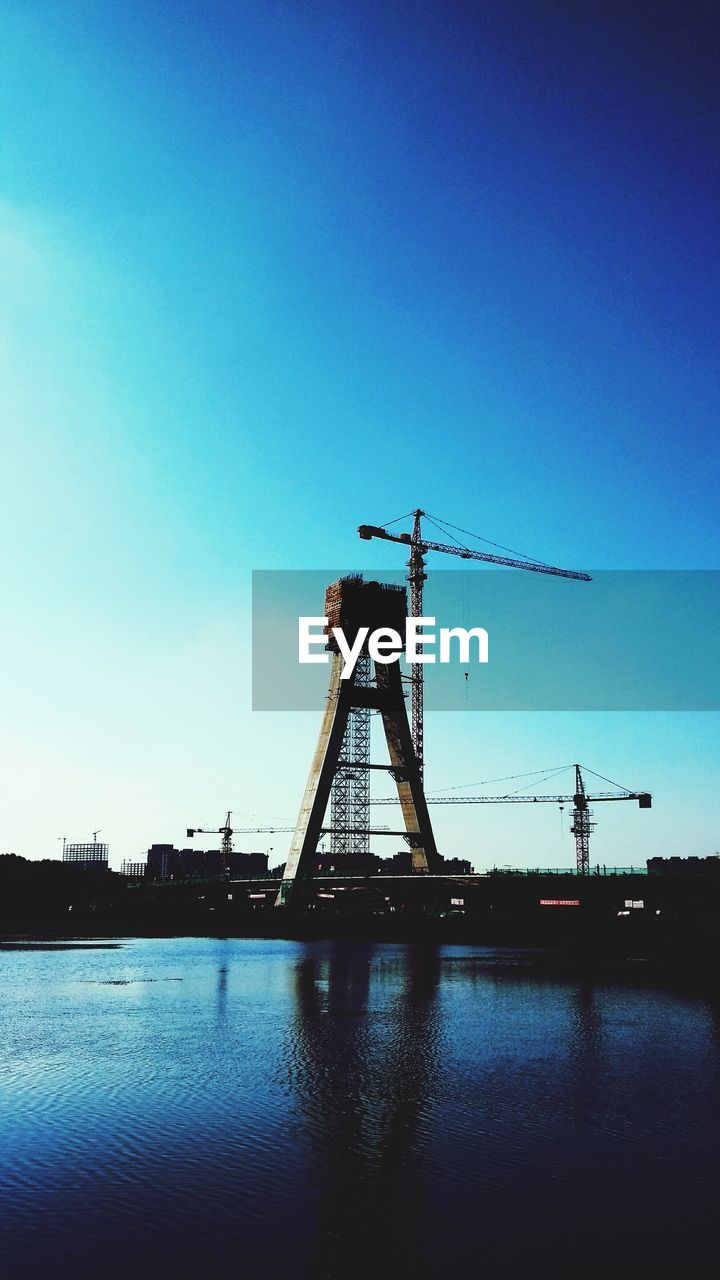 BRIDGE OVER RIVER AGAINST BLUE SKY