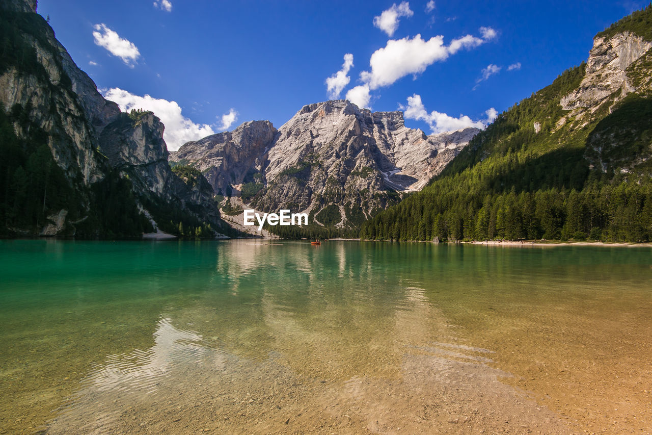 Scenic view of lake by mountains against sky