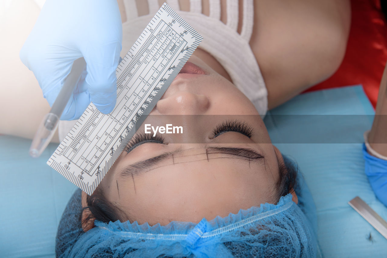 CLOSE-UP OF YOUNG WOMAN LYING ON BED