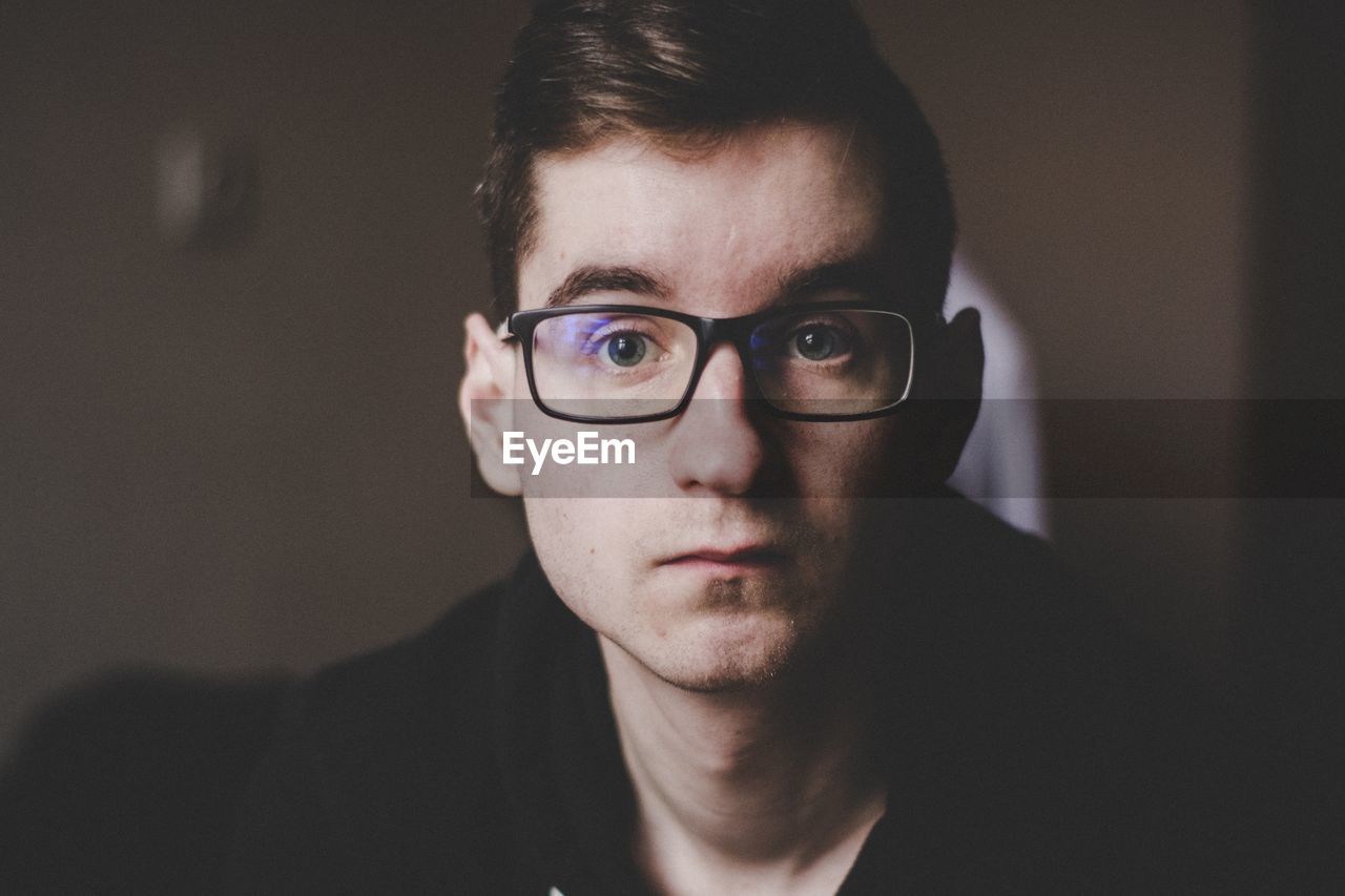 Portrait of young man wearing eyeglasses at home