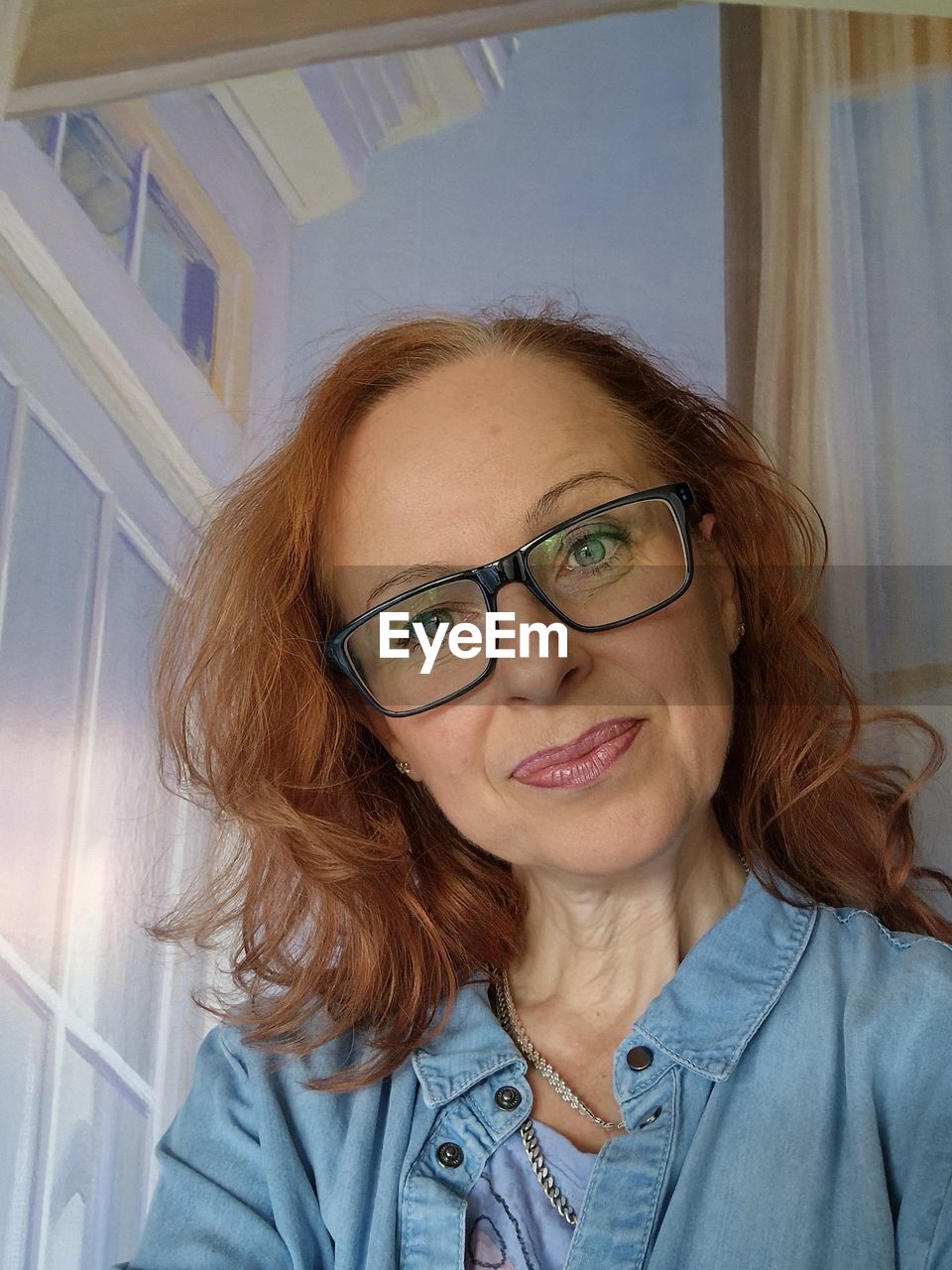 glasses, one person, women, lying down, adult, portrait, human hair, blond hair, indoors, human face, young adult, relaxation, eyeglasses, headshot, high angle view, lifestyles, skin, long hair, hairstyle, person, smiling, leisure activity, happiness, technology, casual clothing, looking at camera, female, emotion, lying on back, brown hair, human head, furniture, home interior, human eye, clothing, wireless technology, redhead, vision care