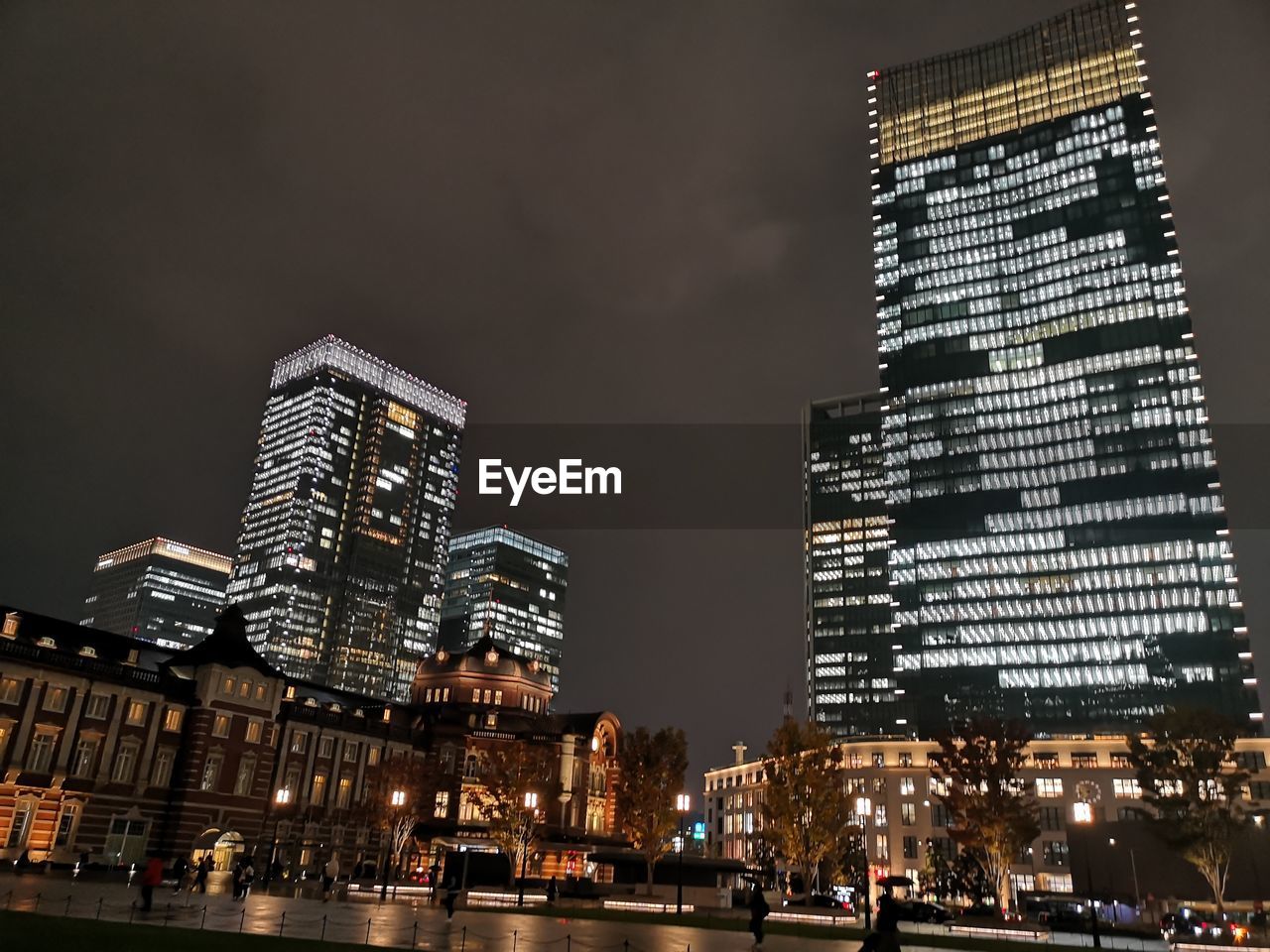 LOW ANGLE VIEW OF ILLUMINATED BUILDINGS AT NIGHT