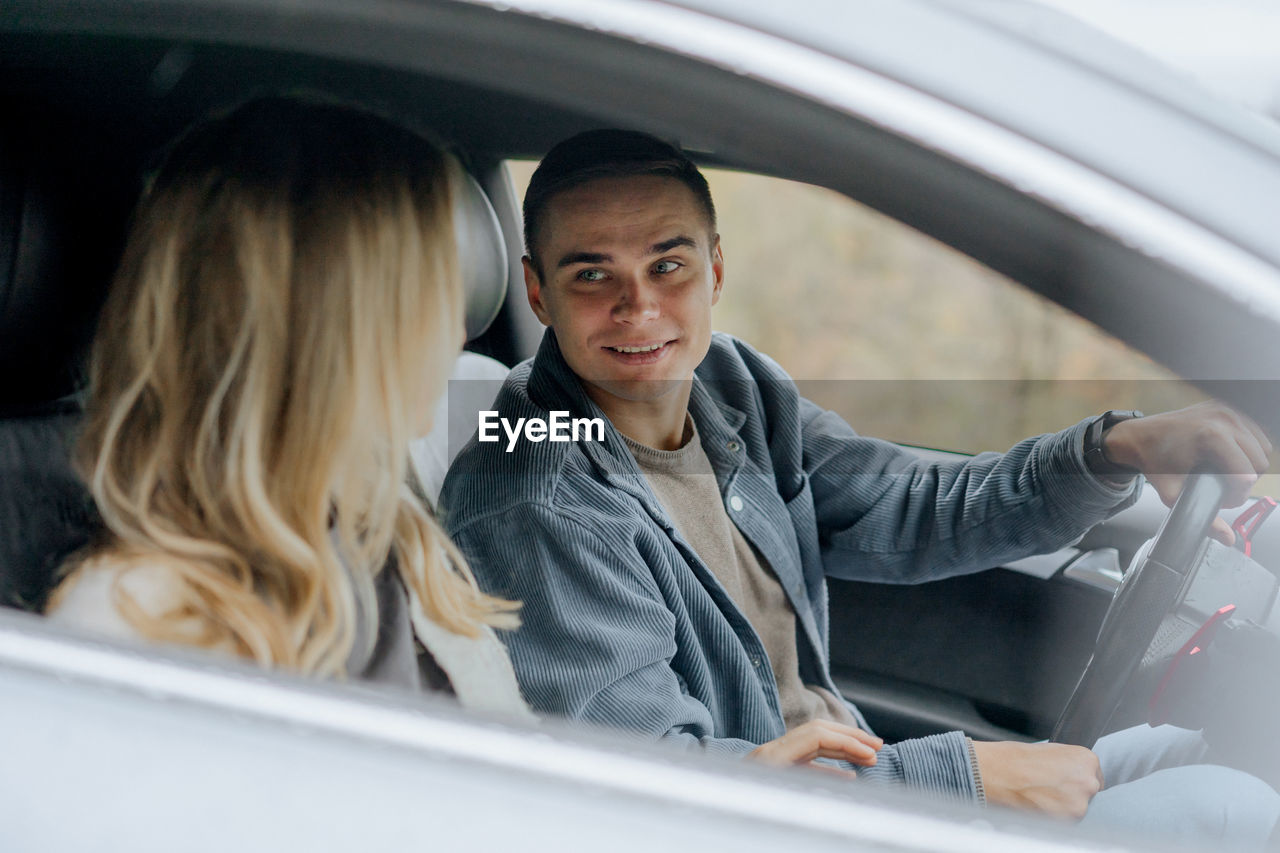 A man and a woman are driving in a car after a date.