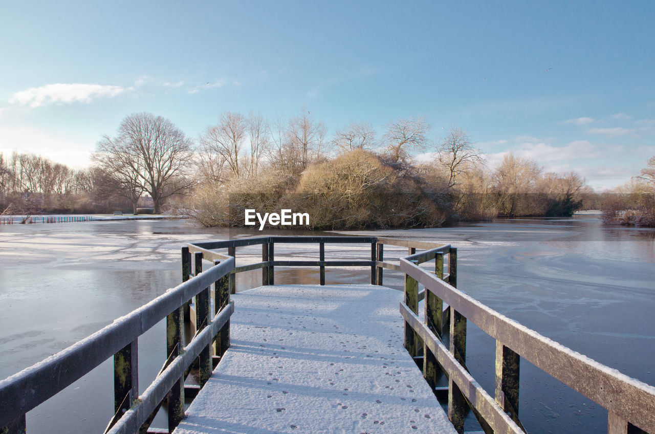 SNOW COVERED FOOTBRIDGE AGAINST SKY