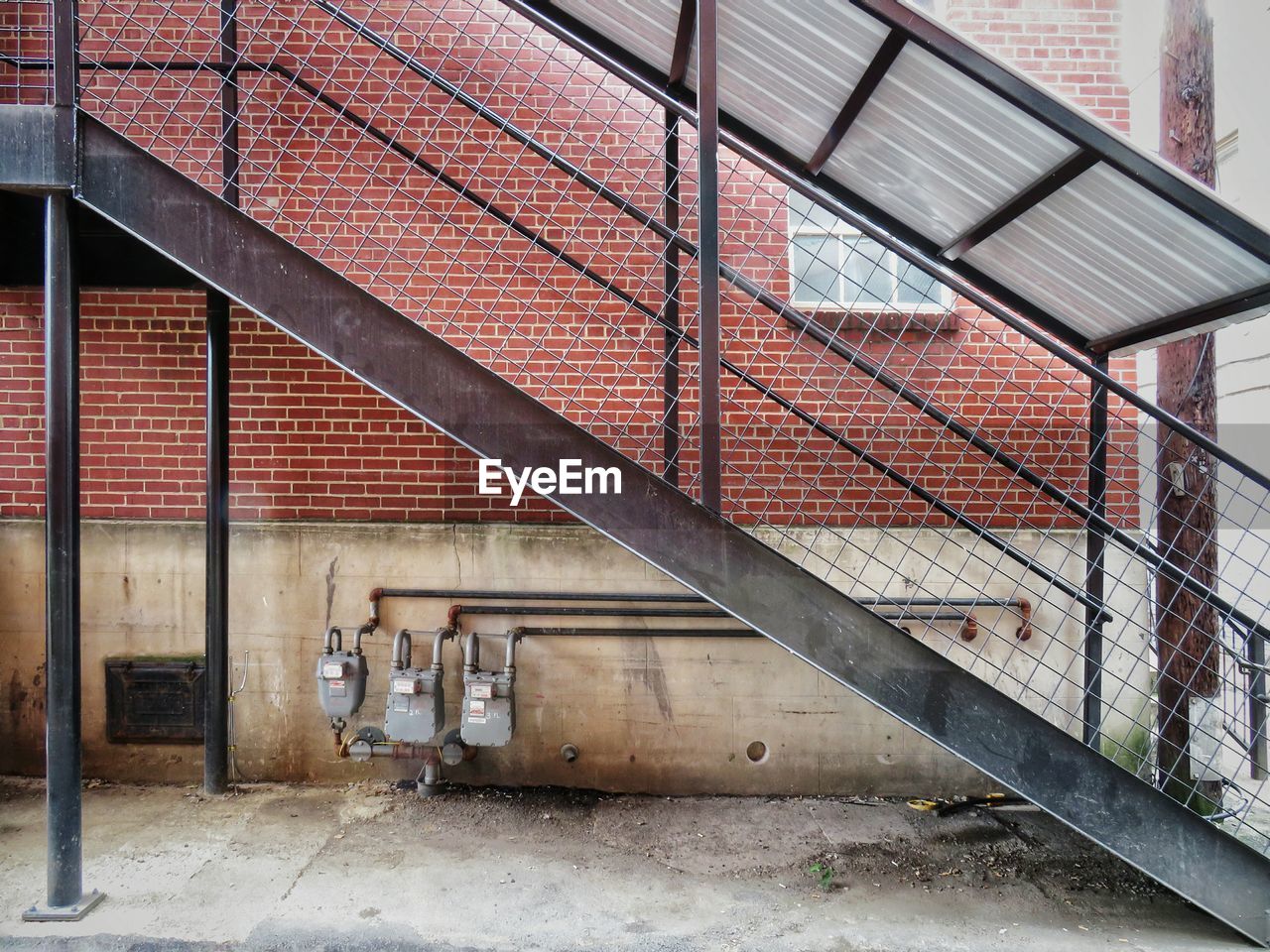 Metal staircase against exterior brick wall