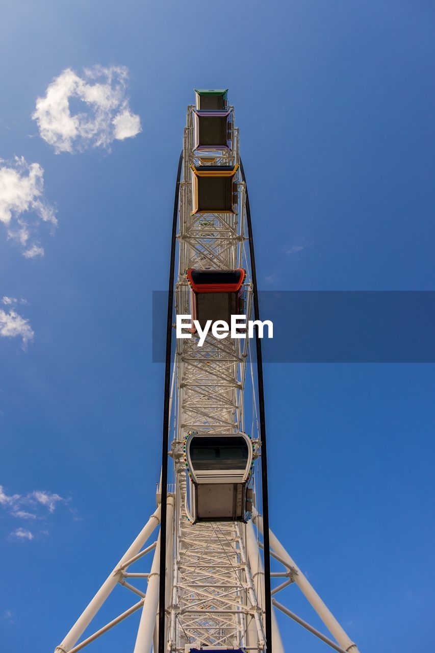 Low angle view of ferris wheel against blue sky