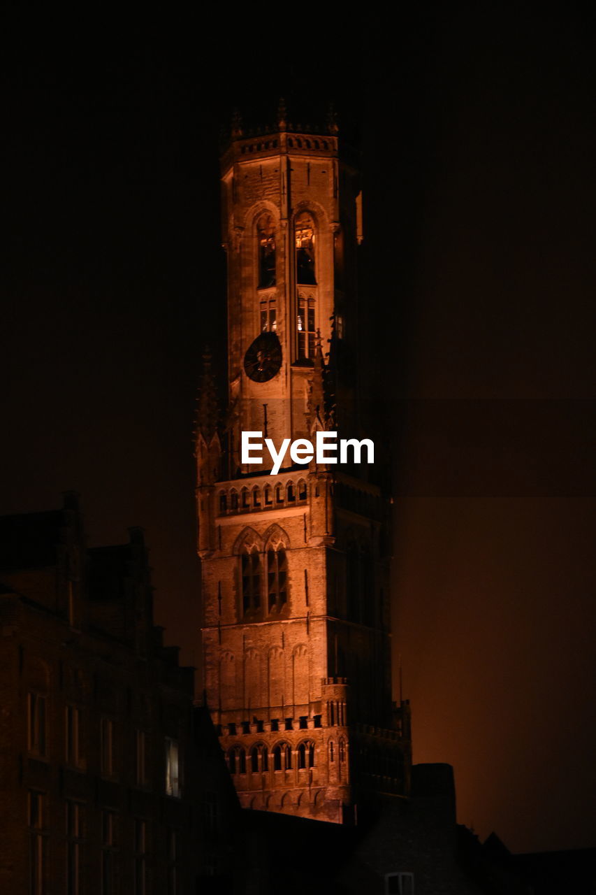 LOW ANGLE VIEW OF CLOCK TOWER AT NIGHT