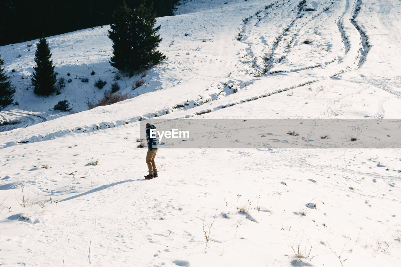 Man learning to snowboard during winter