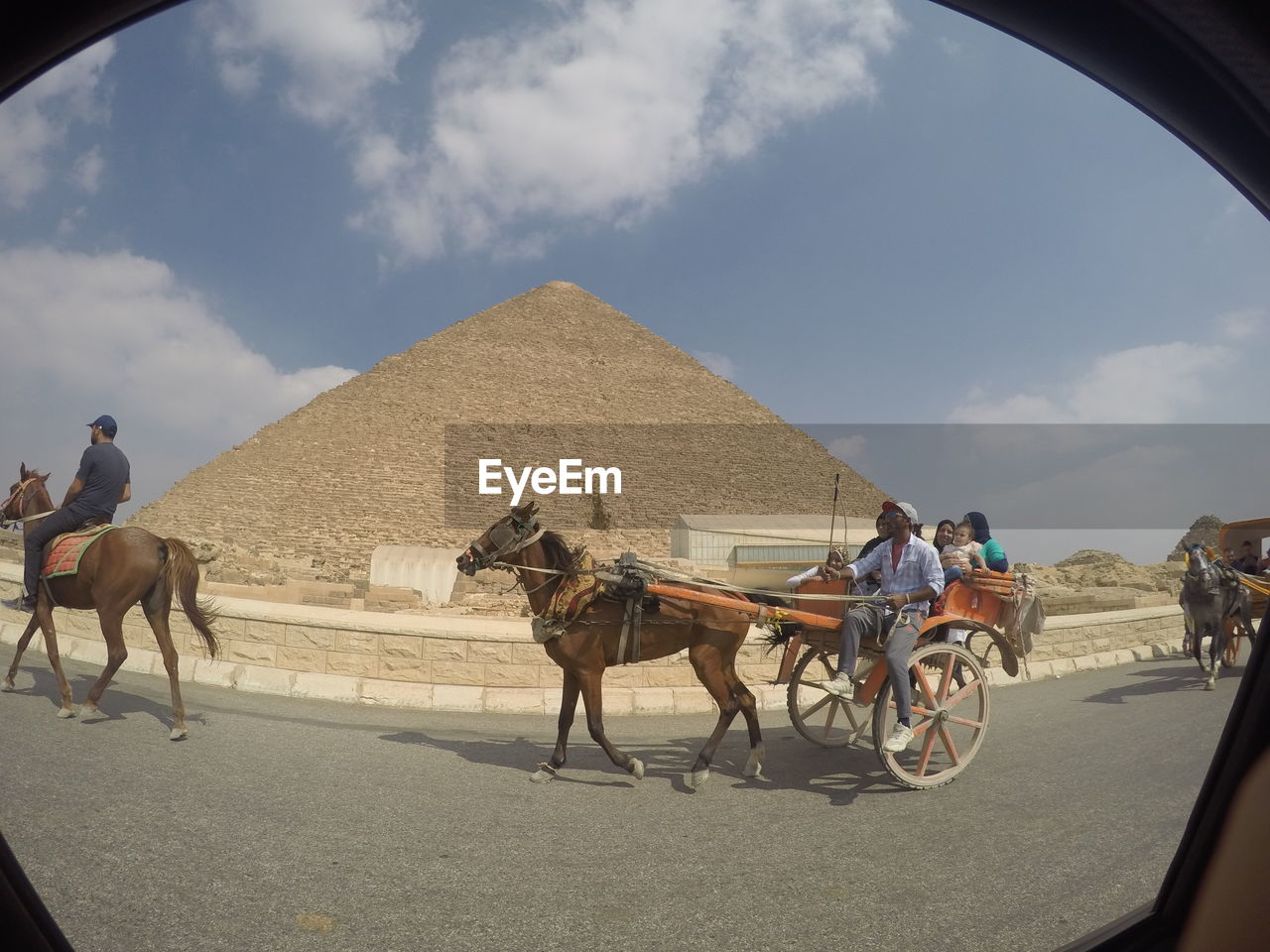 MAN RIDING HORSE CART ON ROAD