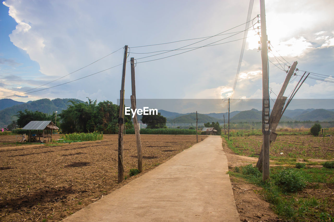 Road amidst field against sky