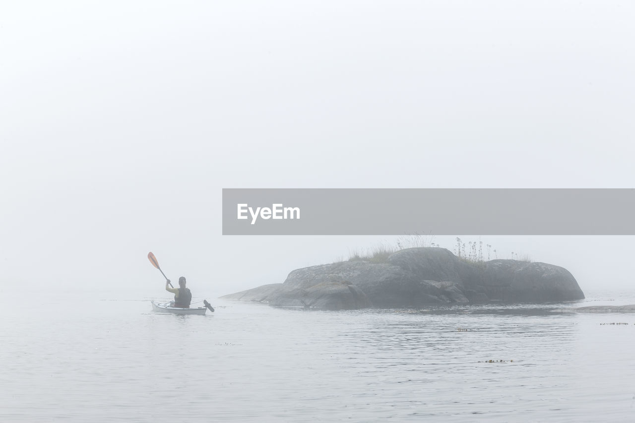 Person paddling in fog, sweden