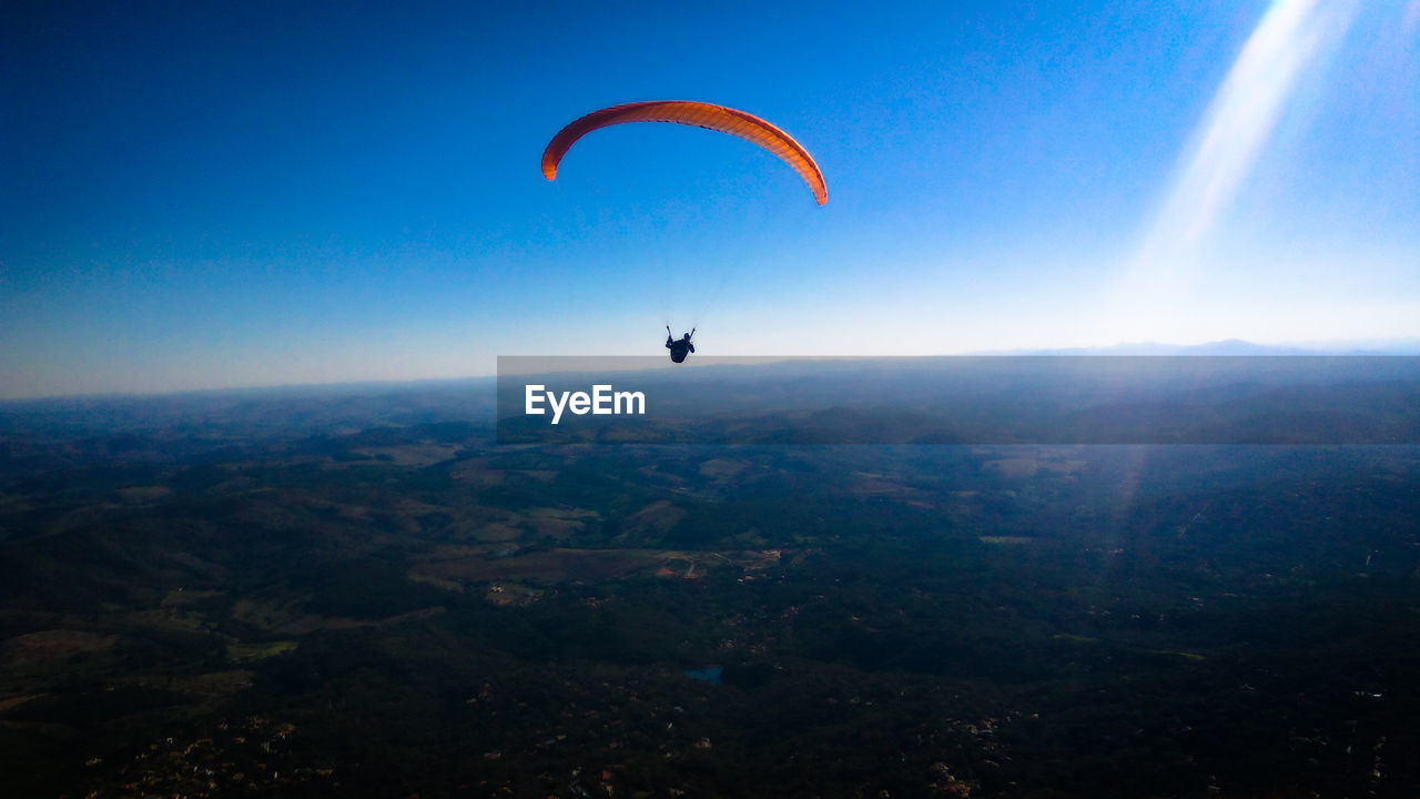 Person paragliding against sky