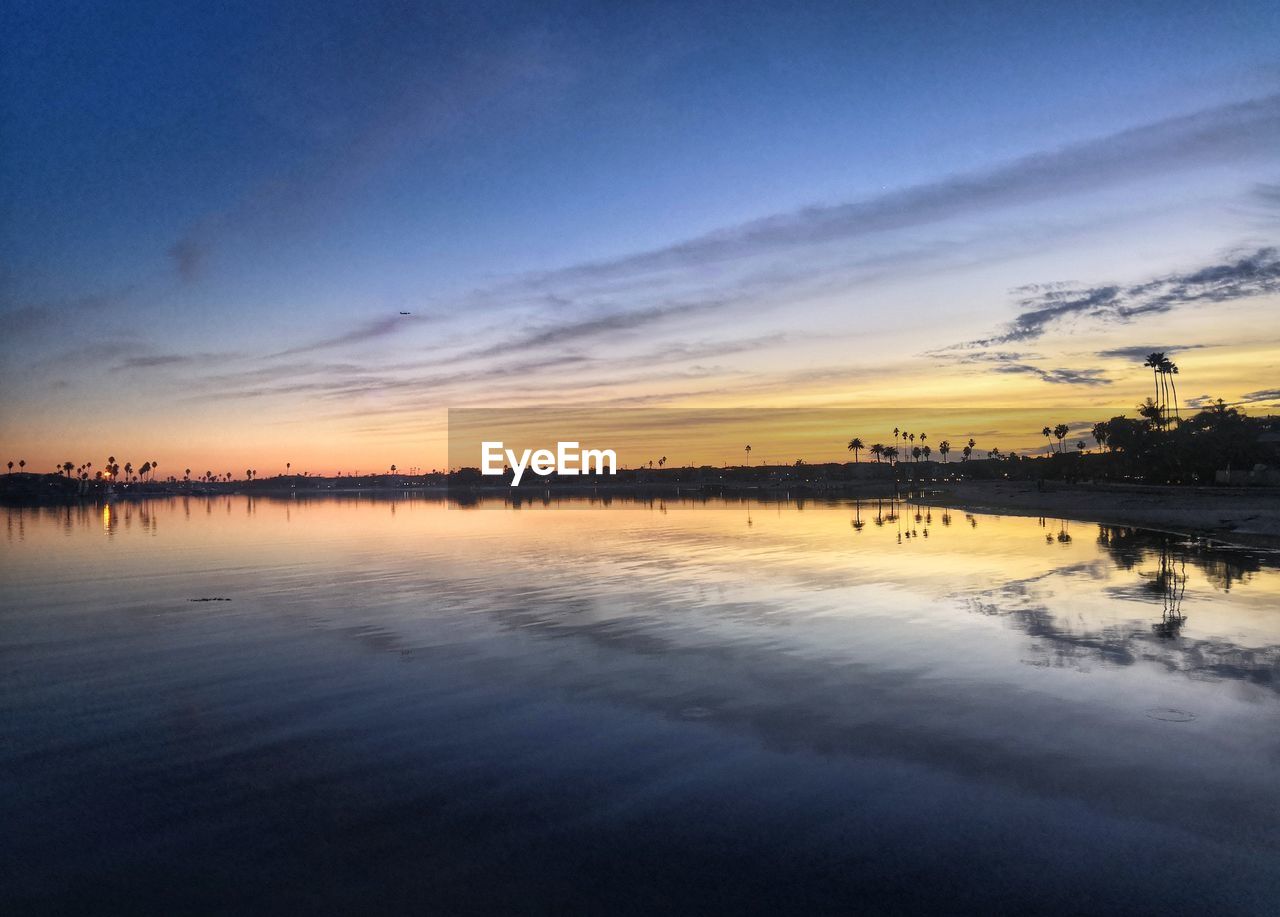 PANORAMIC VIEW OF LAKE AGAINST SKY DURING SUNSET