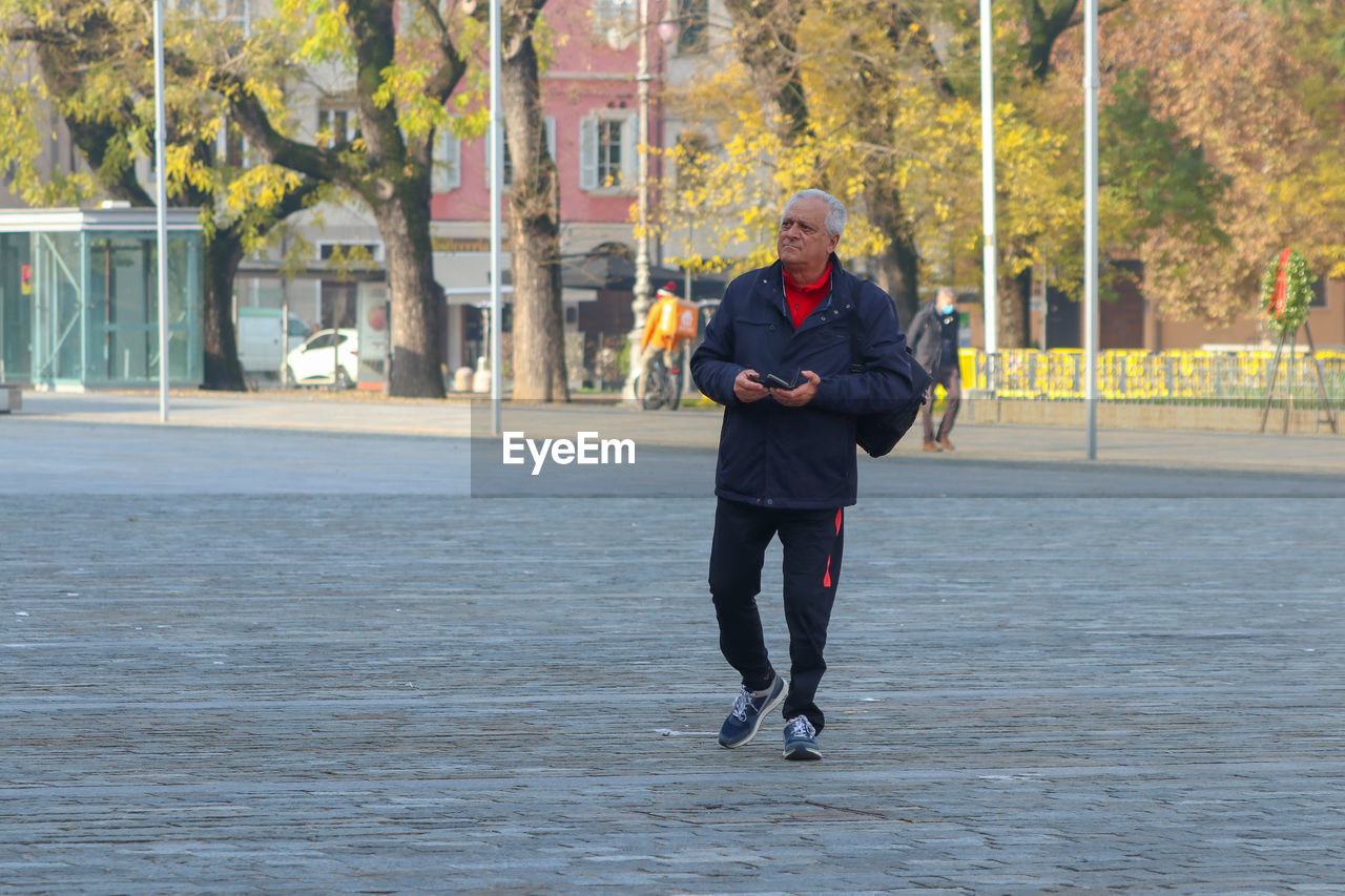 Rear view of man walking on street.