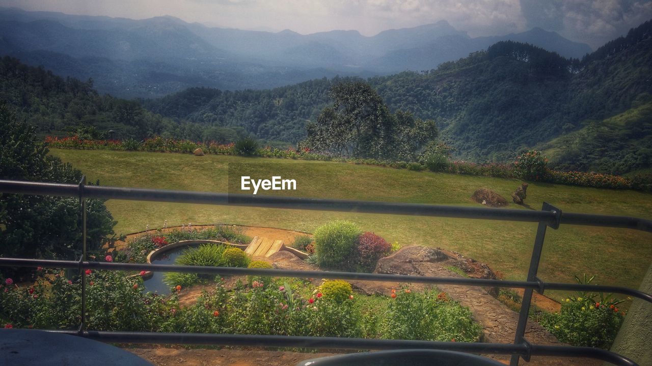 HIGH ANGLE VIEW OF HORSE ON MOUNTAIN AGAINST SKY