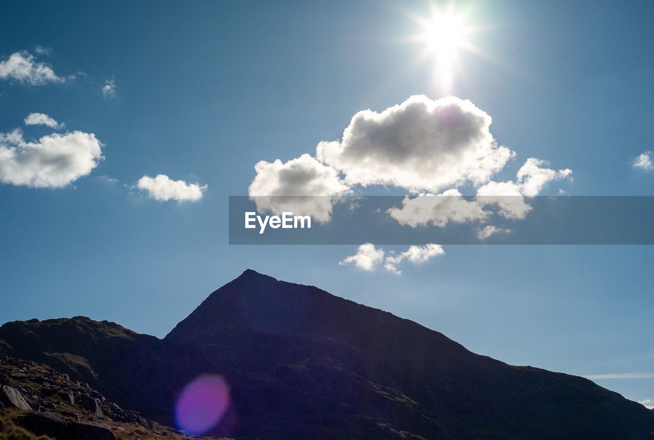 Low angle view of mountains against sky on sunny day