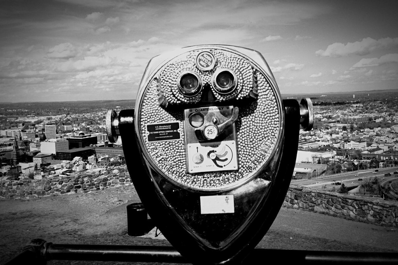 CLOSE-UP OF COIN-OPERATED BINOCULARS WITH CITYSCAPE