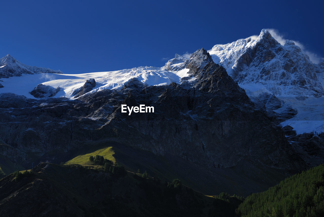 Scenic view of snowcapped mountains against clear sky