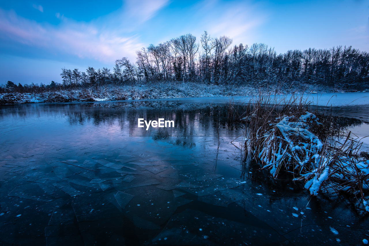 SCENIC VIEW OF FROZEN LAKE AGAINST SKY