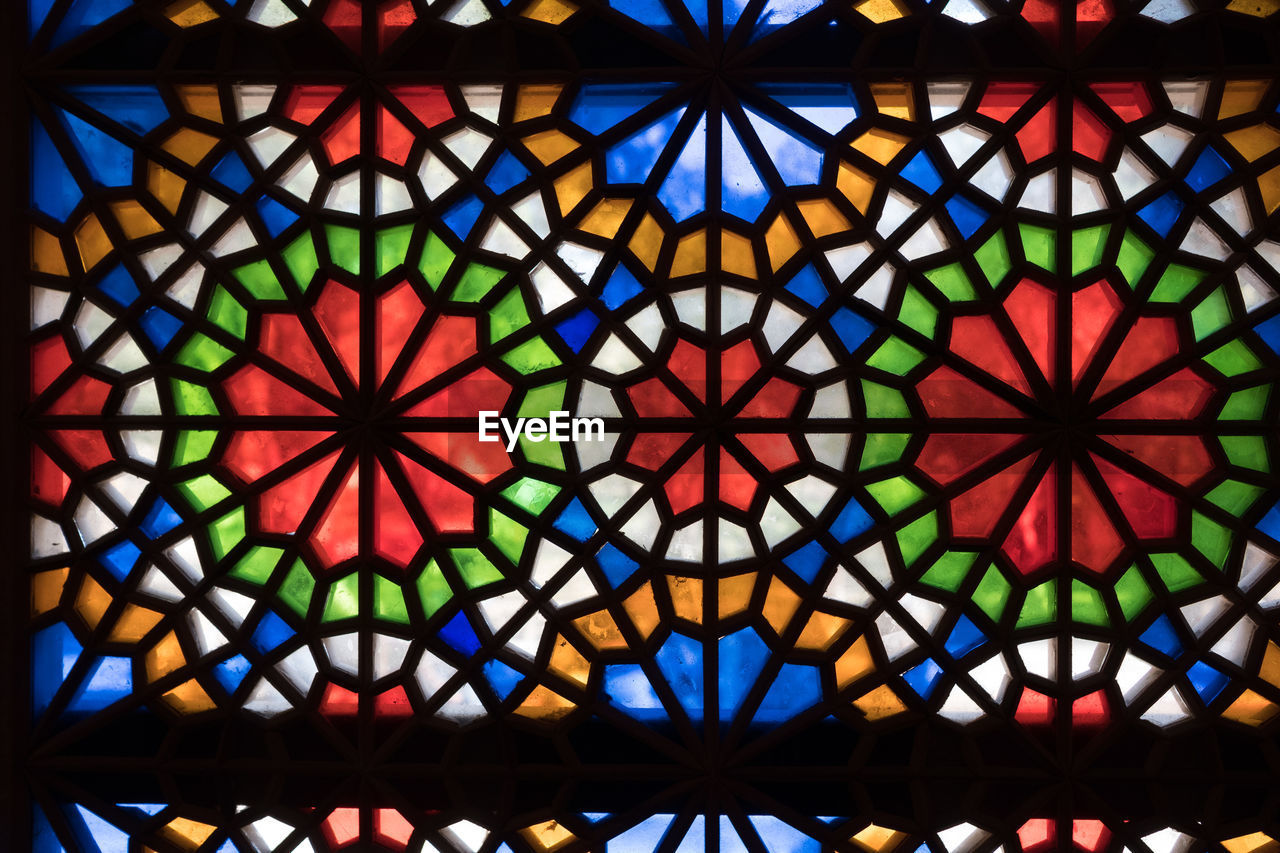 DIRECTLY BELOW SHOT OF MULTI COLORED GLASS CEILING IN CATHEDRAL