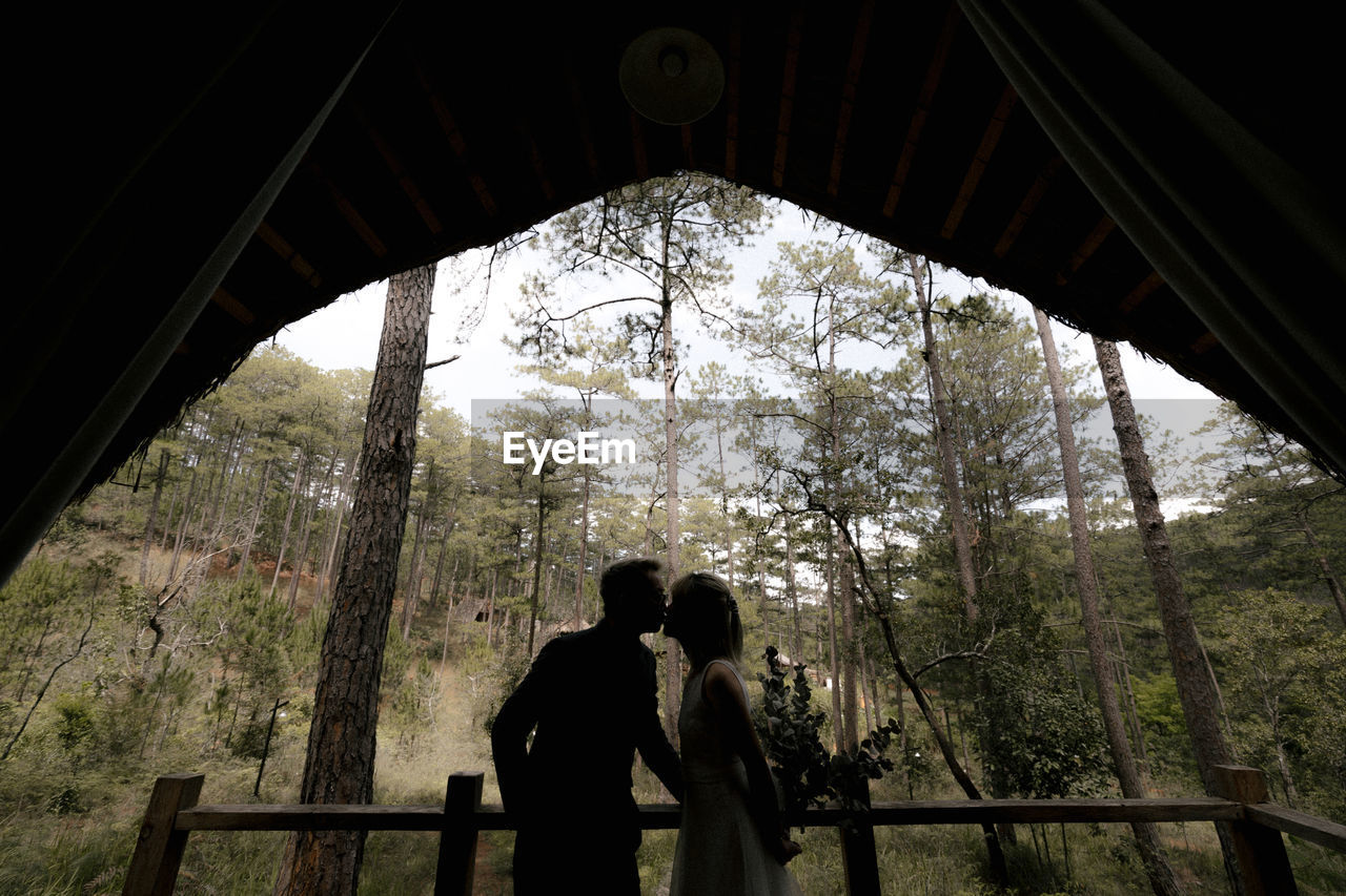 Couple walking on bridge in forest