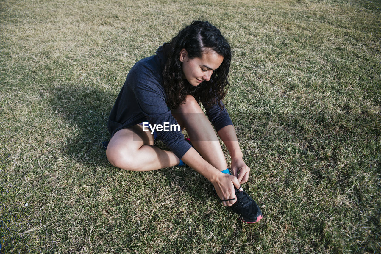 Young woman tying her sneakers