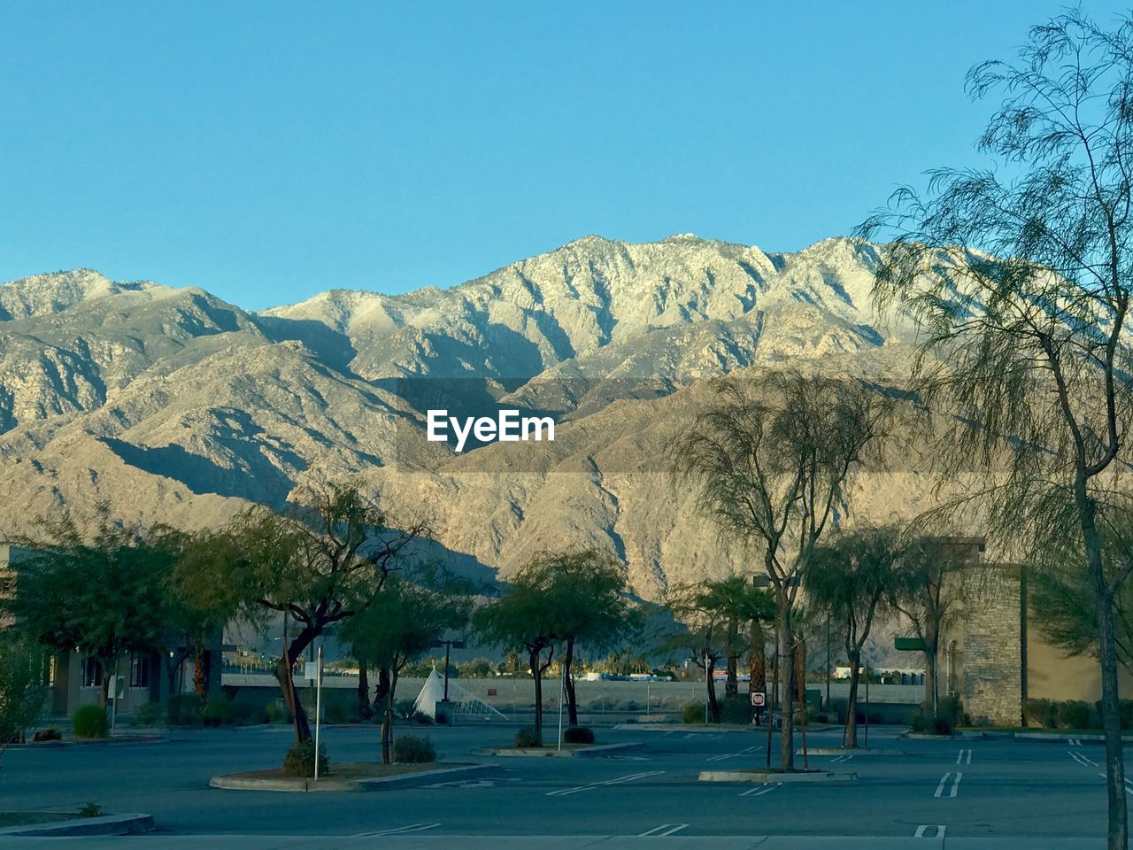 Scenic view of trees and mountains against clear blue sky