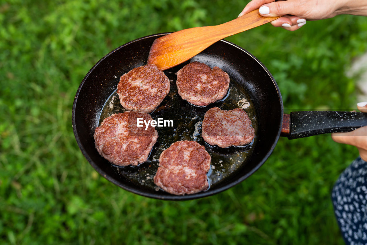 Fried cutlets in a frying pan. top view of a frying pan, woman turning cutlets with a spatula